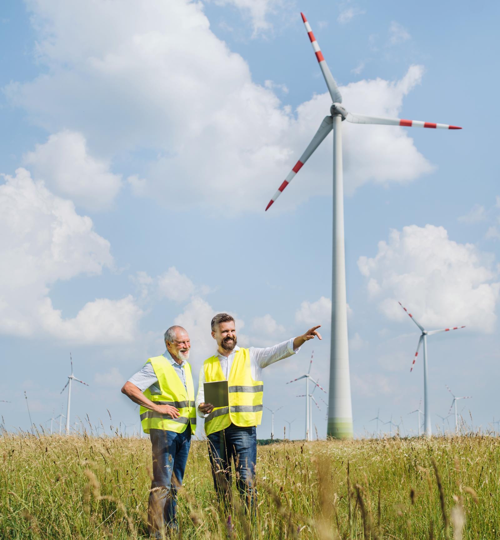 Two men standing in front of a windmill